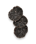 Fresh black truffle slices showing three black truffles for gourmet cooking